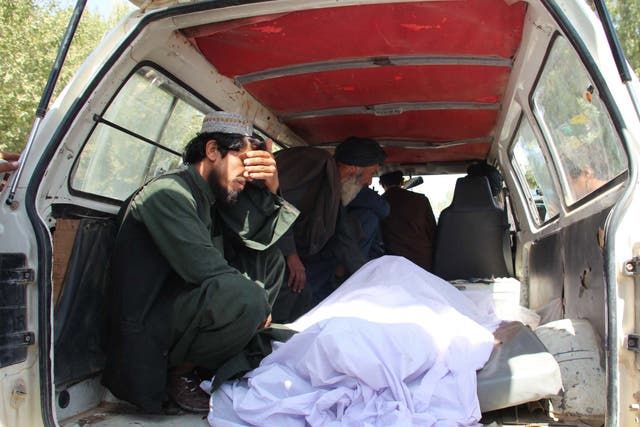 People react beside the bodies of their relatives who were killed in an air raid and ground assault on a Taliban hideout by Afghan special forces, in Helmand