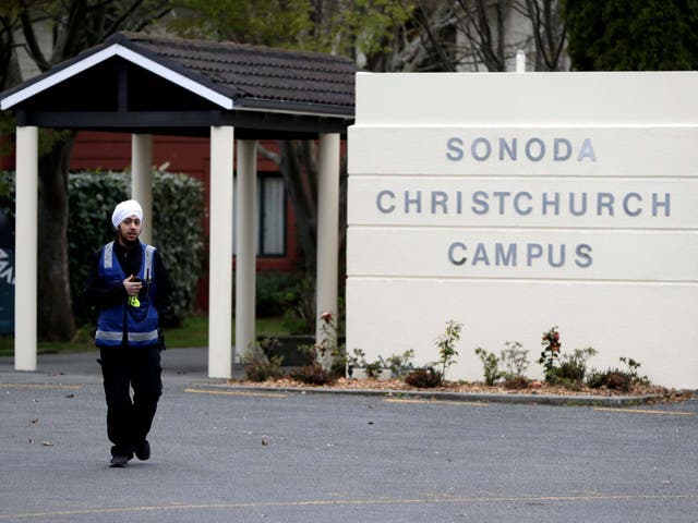 A security guard keeps watch outside student accommodation at Canterbury University in Christchurch, New Zealand where a body was found inside