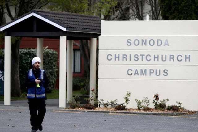 A security guard keeps watch outside student accommodation at Canterbury University in Christchurch, New Zealand where a body was found inside