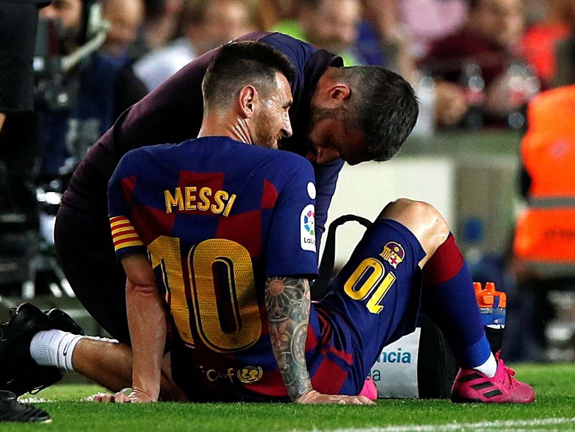 Barcelona's Lionel Messi is attended by medical staff after sustaining an injury