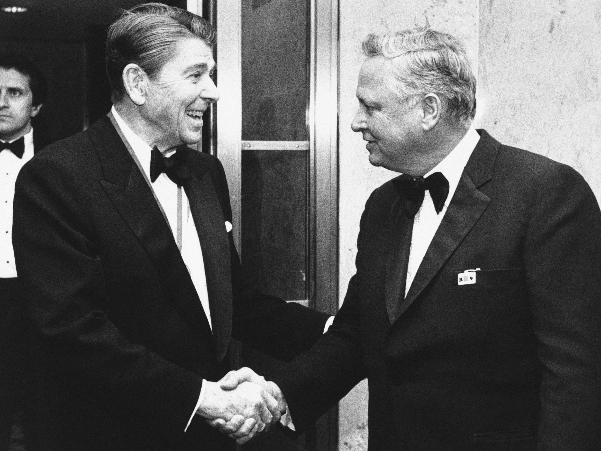 Ronald Reagan (left) shakes hands with Hilton upon his arrival at Capitol Hill in 1985