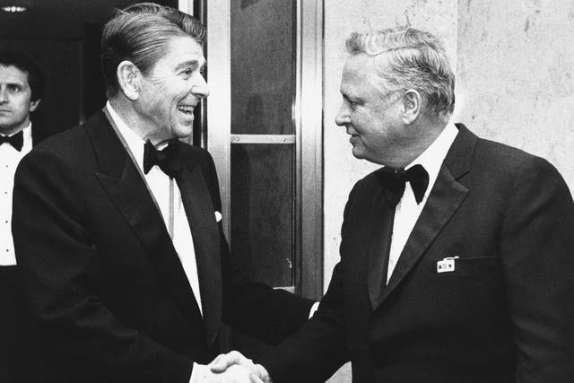 Ronald Reagan (left) shakes hands with Hilton upon his arrival at Capitol Hill in 1985