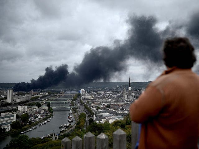 A man looks at smoke billowing from a Seveso classified Lubrizol factory on fire near Rouen.