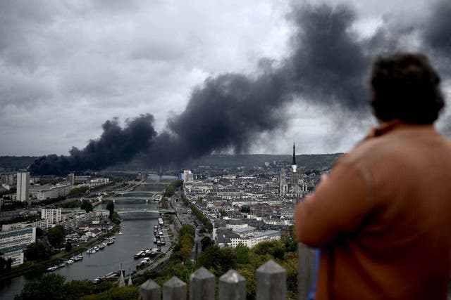 A man looks at smoke billowing from a Seveso classified Lubrizol factory on fire near Rouen.