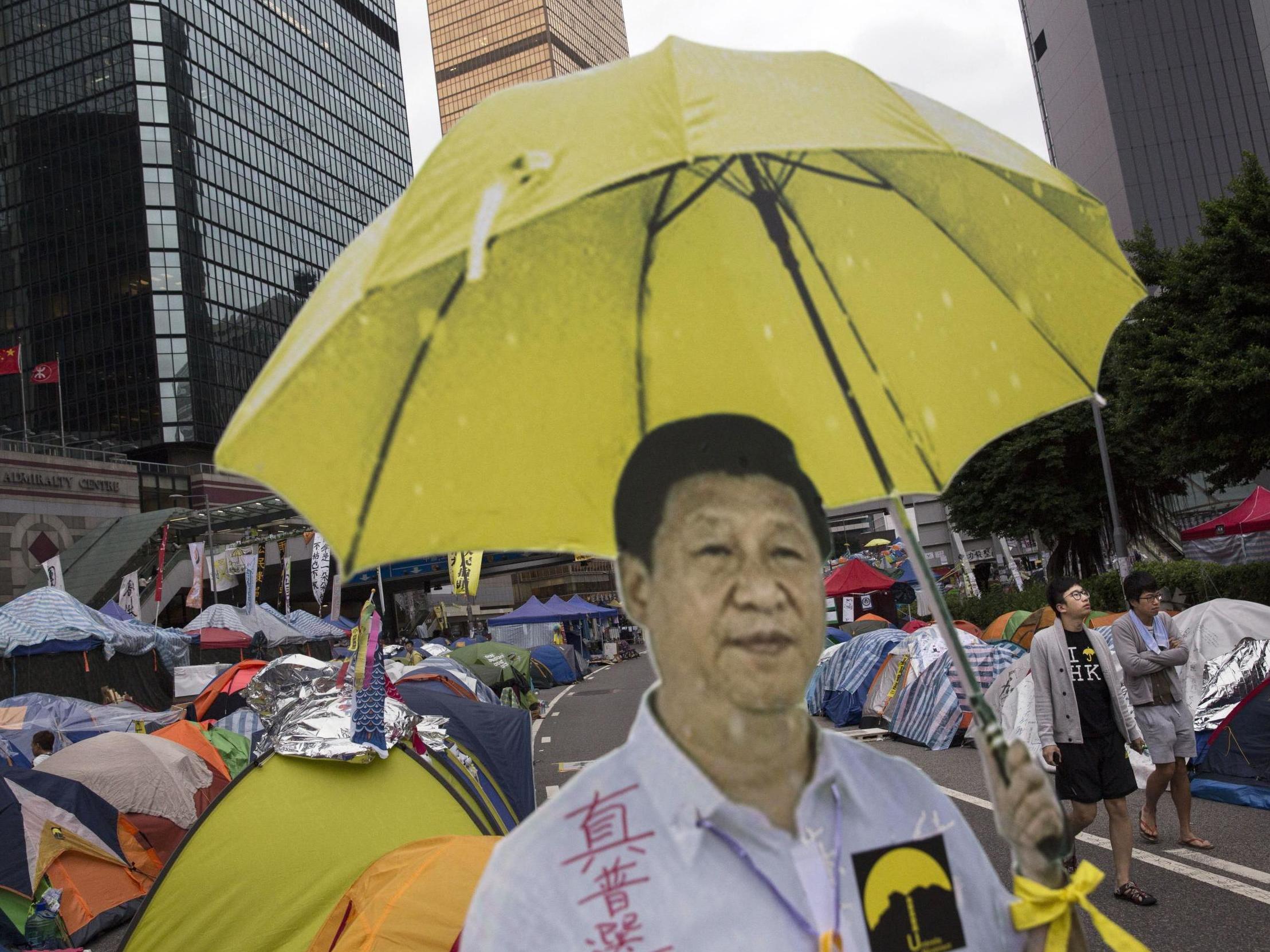Hong Kong protesters used a cardboard cut-out of Chinese president Xi Jinping holding a yellow umbrella, the symbol of their movement – the real Xi is hoping for blue skies on Tuesday
