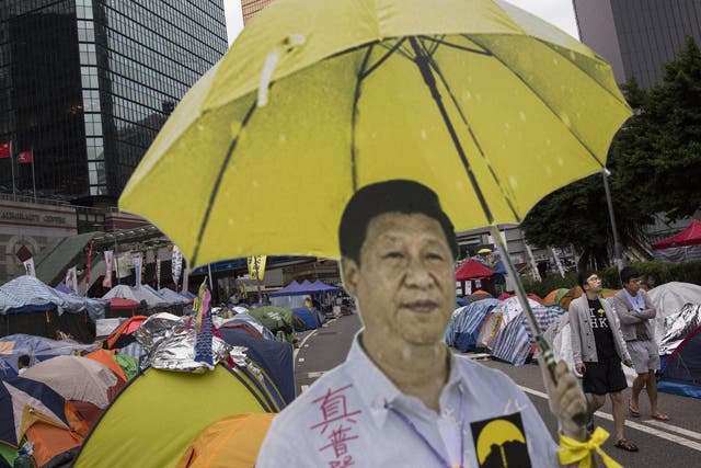 Hong Kong protesters used a cardboard cut-out of Chinese president Xi Jinping holding a yellow umbrella, the symbol of their movement – the real Xi is hoping for blue skies on Tuesday