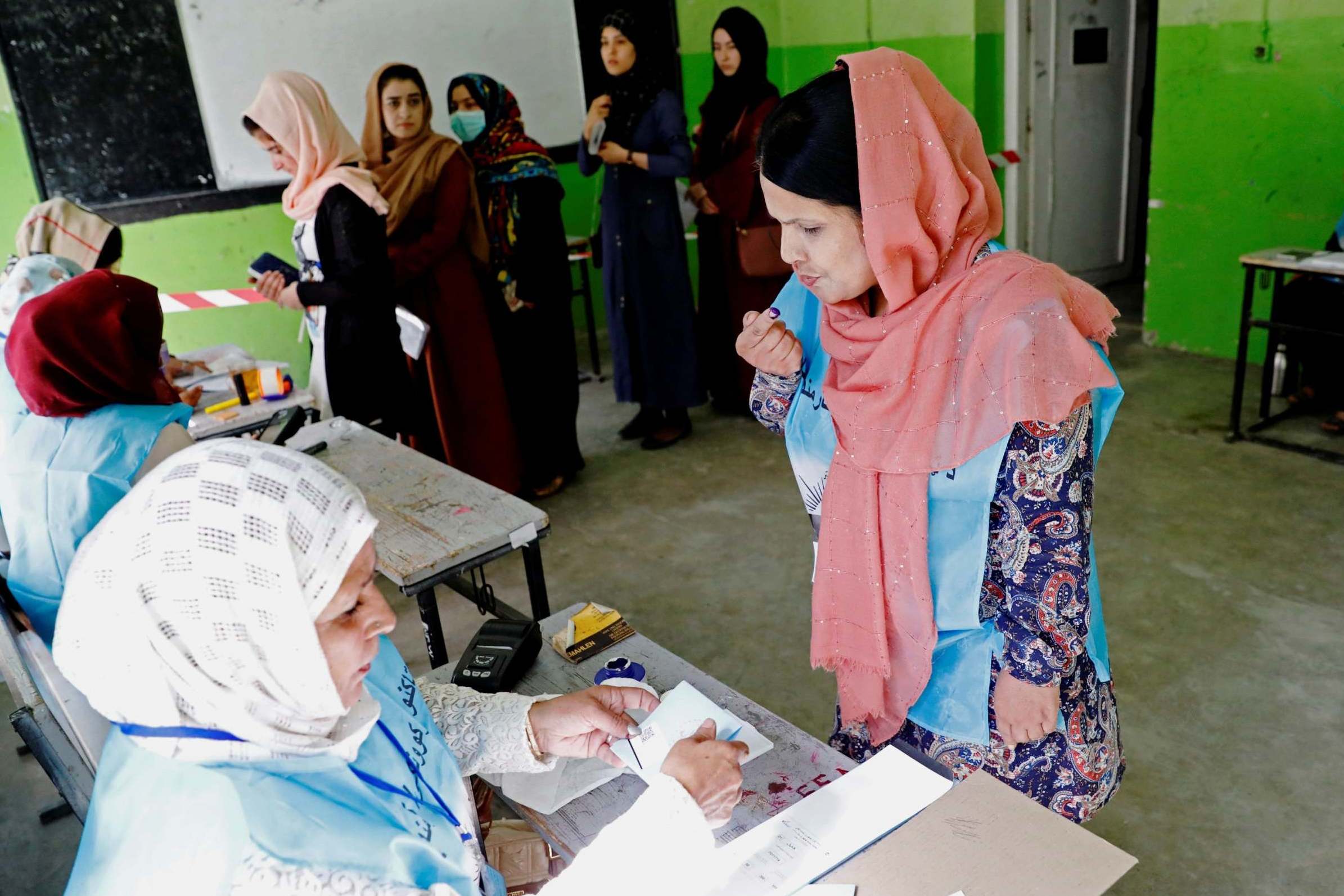 Afghan women cast their votes on a day that saw outbreaks of violence across the country