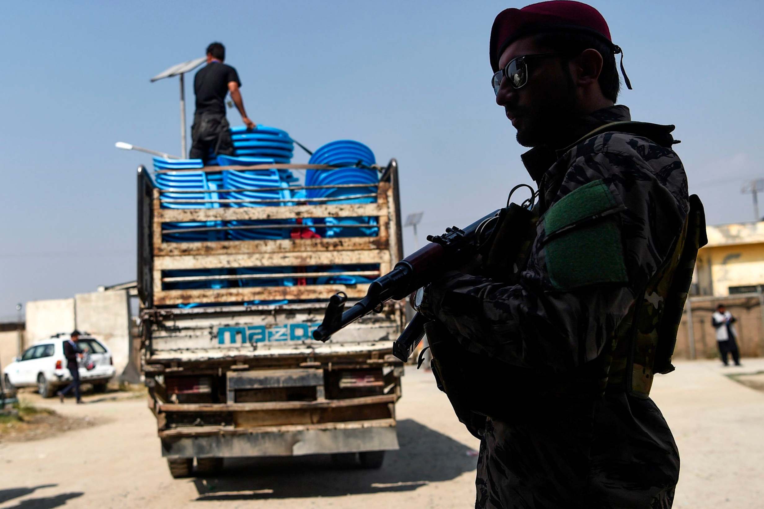 A security personnel stands guard as Independent Election Commission (IEC) workers unload ballot boxes from a truck to be taken to a counting centre the day after Afghanistan held presidential elections