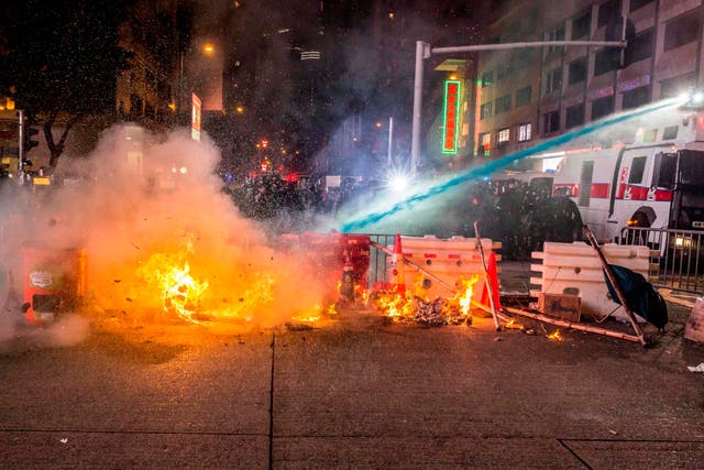 A water cannon is used to put out a fire during clashes with police following an unsanctioned march through Hong Kong on Sunday
