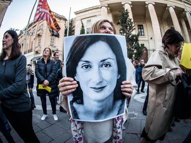 A protester holds a poster of Daphne Caruana Galizia, assassinated in a car bomb attack in 2017, during a vigil demanding justice