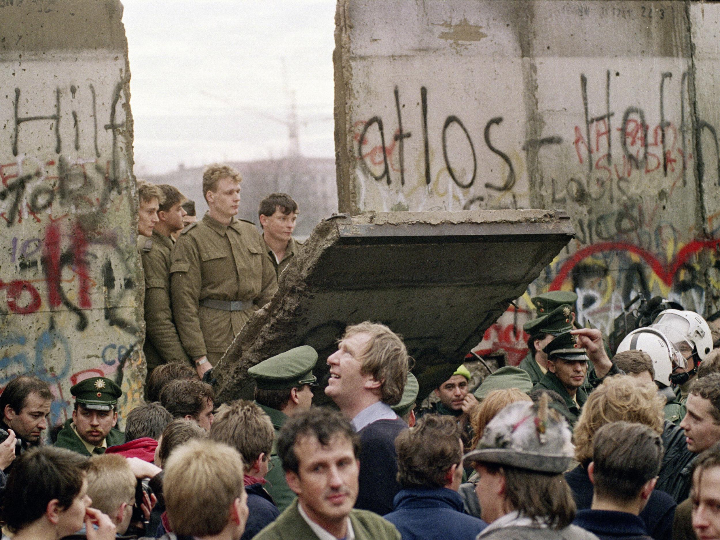 11 November 1989: East German border guards demolish a section of the wall to open a new crossing point between East and West Berlin