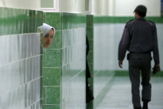 A prison guard walks by an inmate at the infamous Evin prison, north of Tehran, where several British citizens are reportedly being held on spying charges