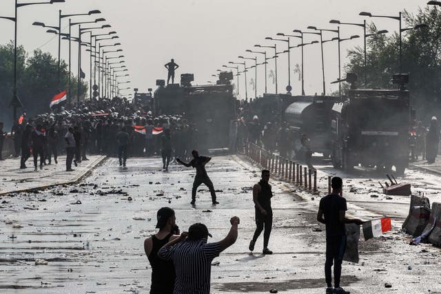 Protesters clash with Iraqi riot police vehicles during a demonstration on Tuesday