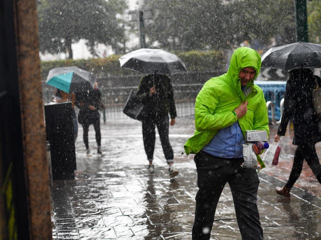 People make their way through a heavy rain shower in Birmingham on Tuesday