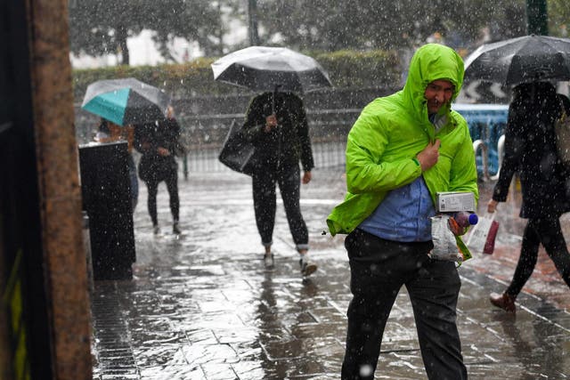 People make their way through a heavy rain shower in Birmingham on Tuesday