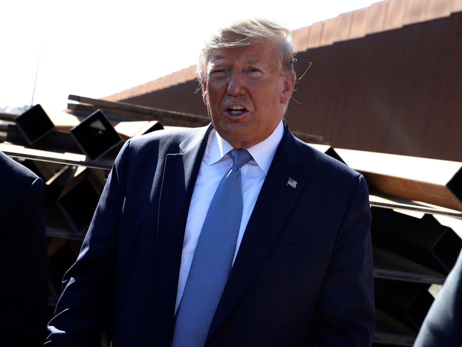 President Donald Trump talks with reporters as he tours a section of the southern border wall