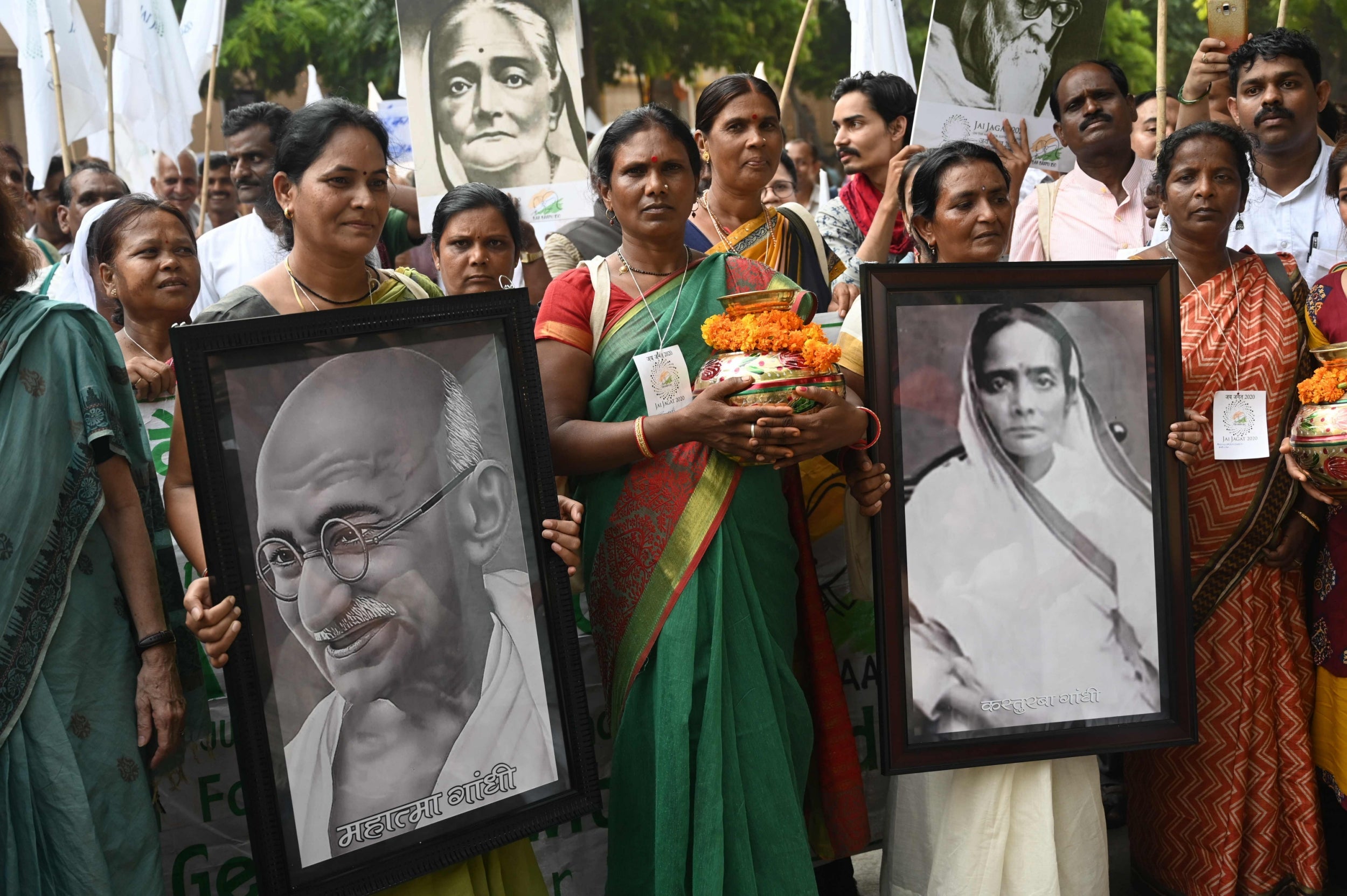 Activists hold portraits of Indian independence icon Mahatma Gandhi and his wife Kasturba Gandhi as they mark his 150th birth anniversary with a peace march from Delhi to Geneva