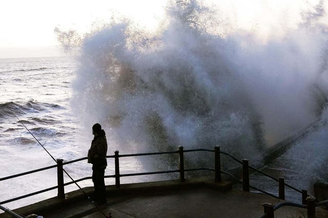 Waves crash against a sea wall in Durham