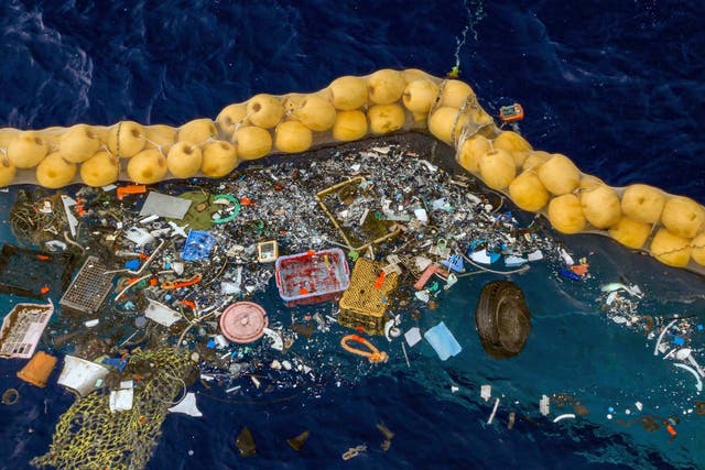 Plastic is retained in front of an extended cork line in the Pacific Ocean by the system designed by Boyan Slat