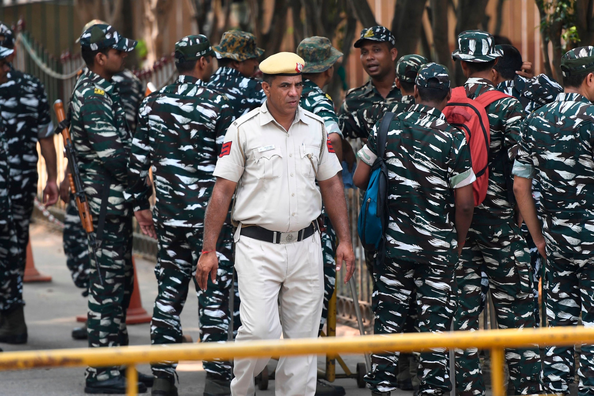 Police gather at the AIIMS trauma centre in New Delhi where a teenage rape victim is giving testimony to a judge after being critically injured in a suspicious car crash in July