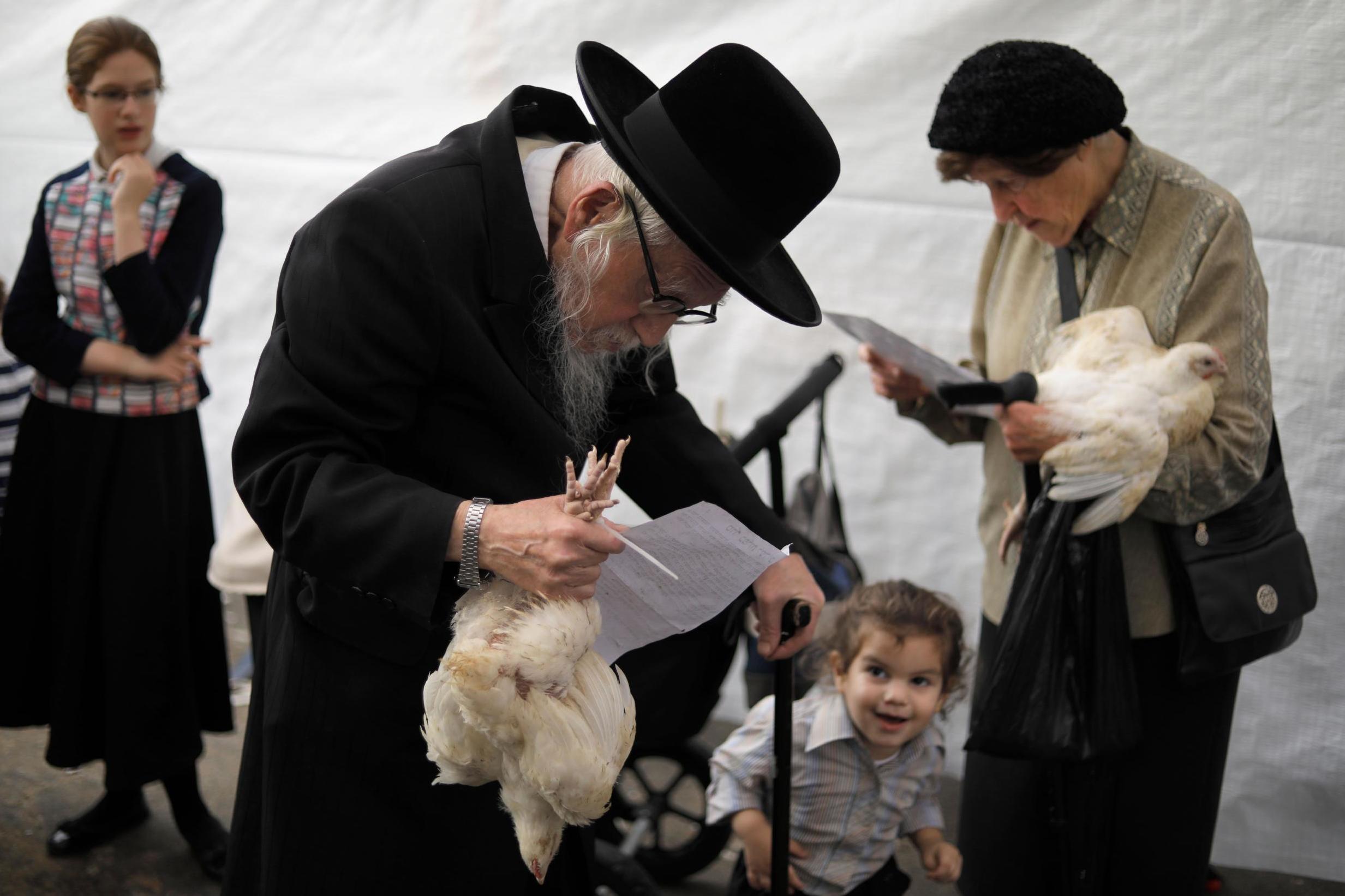 Orthodox Jews during the Kapparot ceremony; the ritual is supposed to transfer sins to the chicken, which is waved above the head and then slaughtered