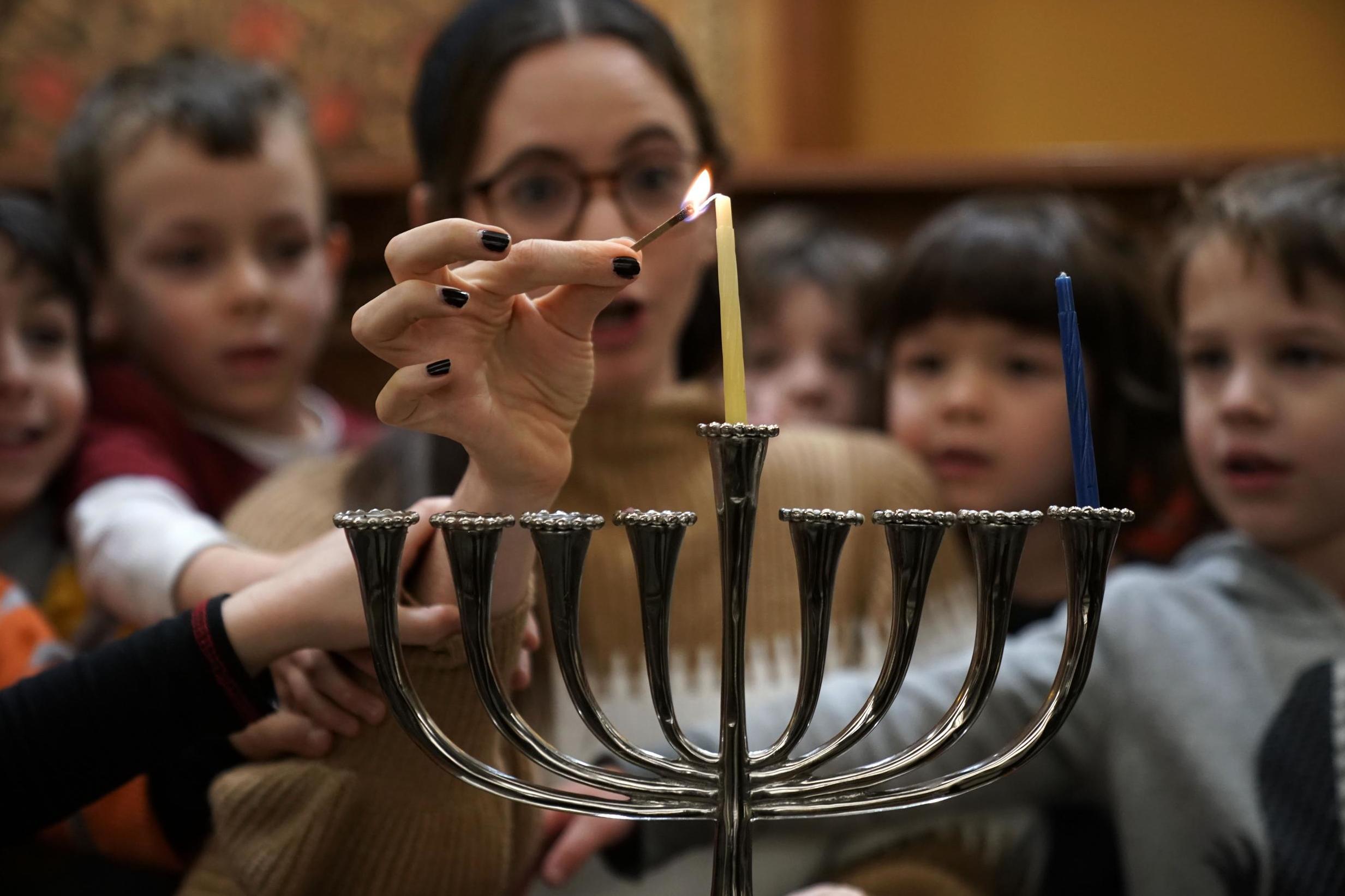 Nursery children learn how to light a Hanukah menorah in Washington; the festival begins on 22 December