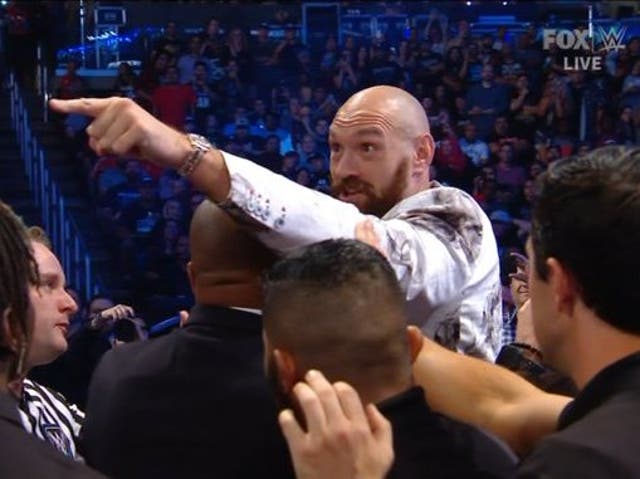 Tyson Fury had to be restrained after jumping the barricade at a WWE event