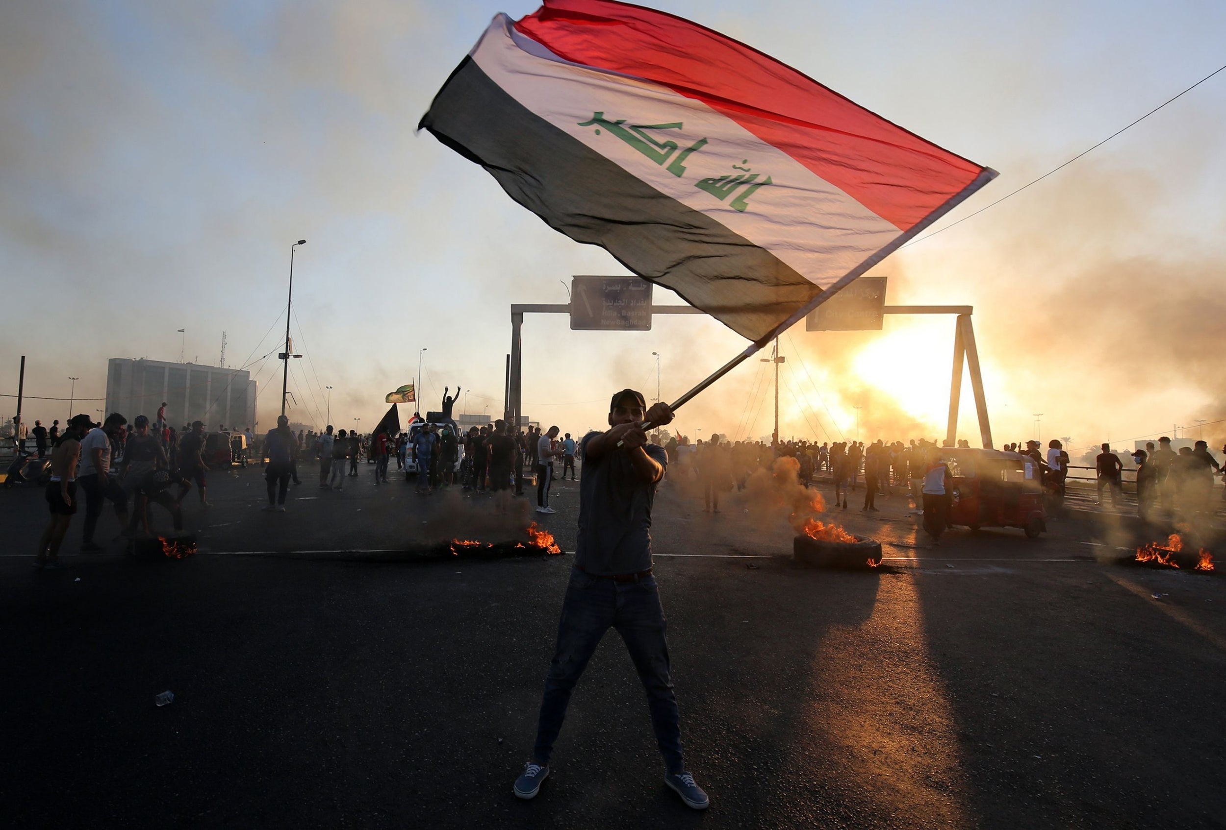 An Iraqi protester waves the national flag during a demonstration against state corruption, failing public services and unemployment