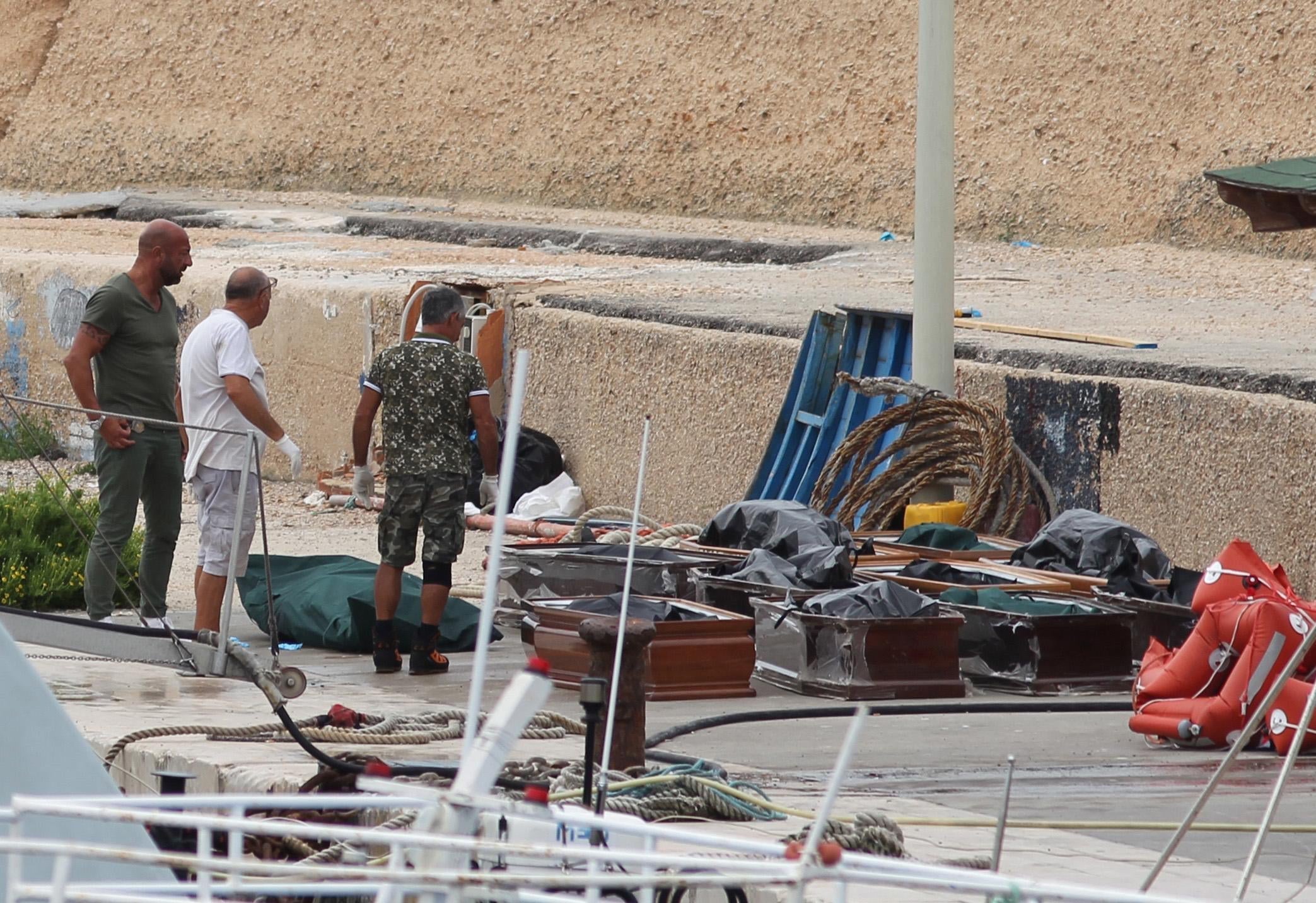 The coffins with the bodies of migrants boat accident victims lined up on the quay in the port of Lampedusa the morning they were pulled from the water