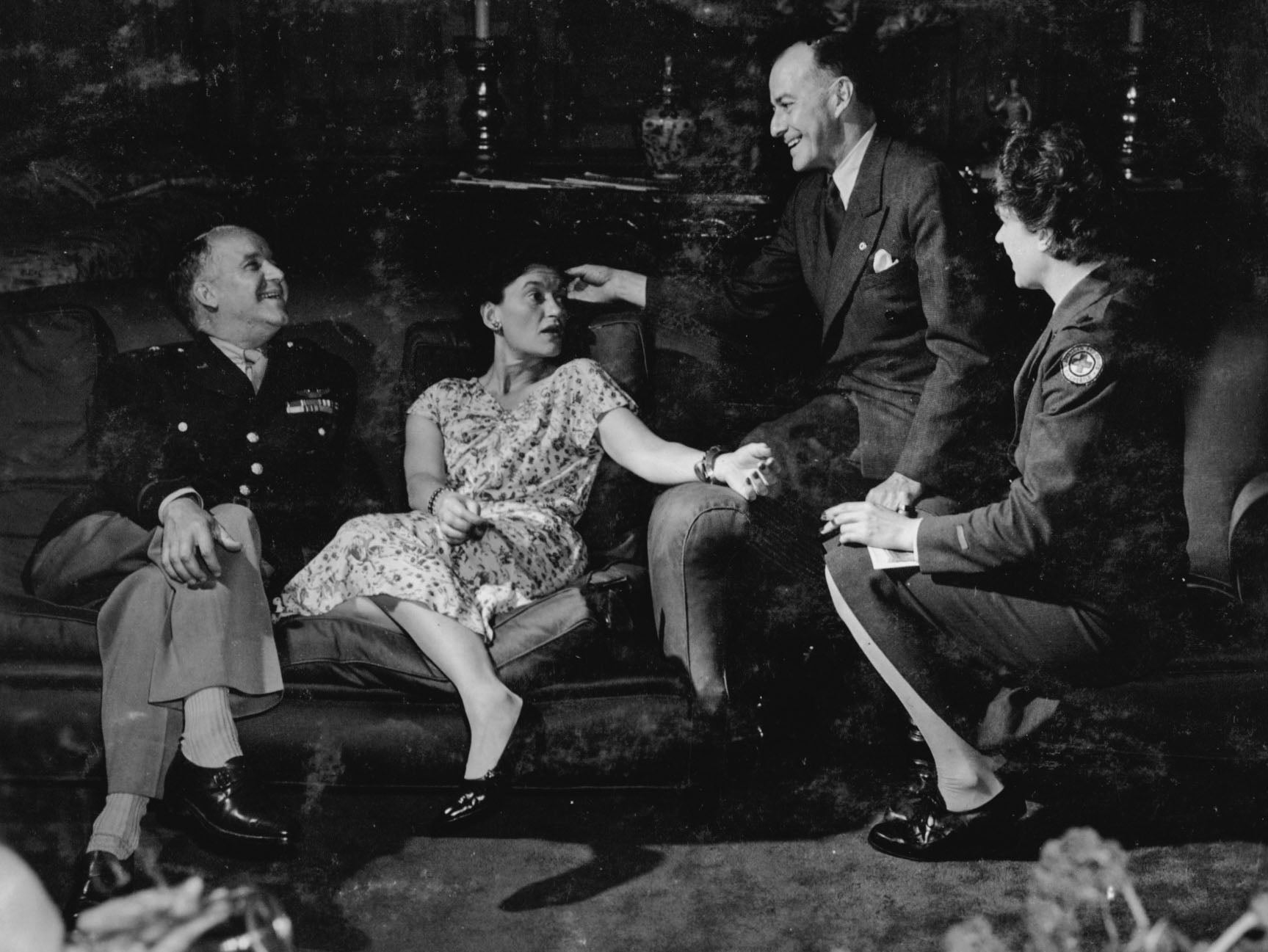 Gertie enjoyed a hectic social life when time allowed; here she sits on a couch with friends at a party at her London home in 1944