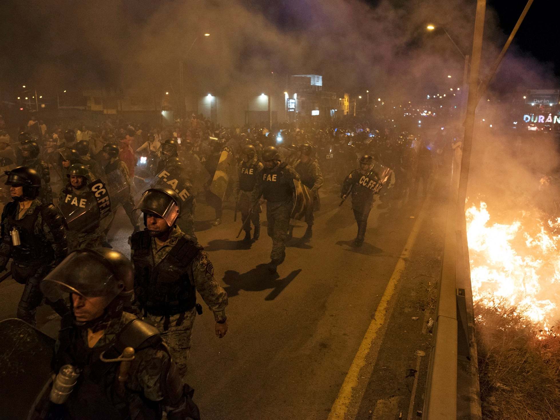 Soldiers walk near burning barricades during protests