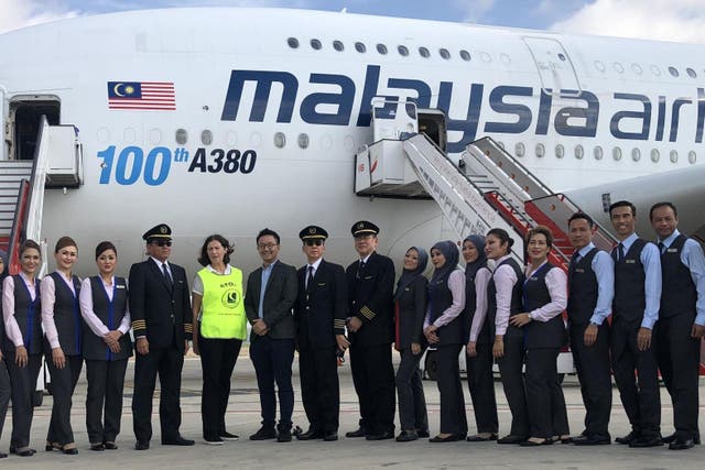 Rescue mission: Dame Deirdre Hutton (highly visible), chair of the Civil Aviation Authority, with the crew of a Malaysia Airlines jet at Palma airport