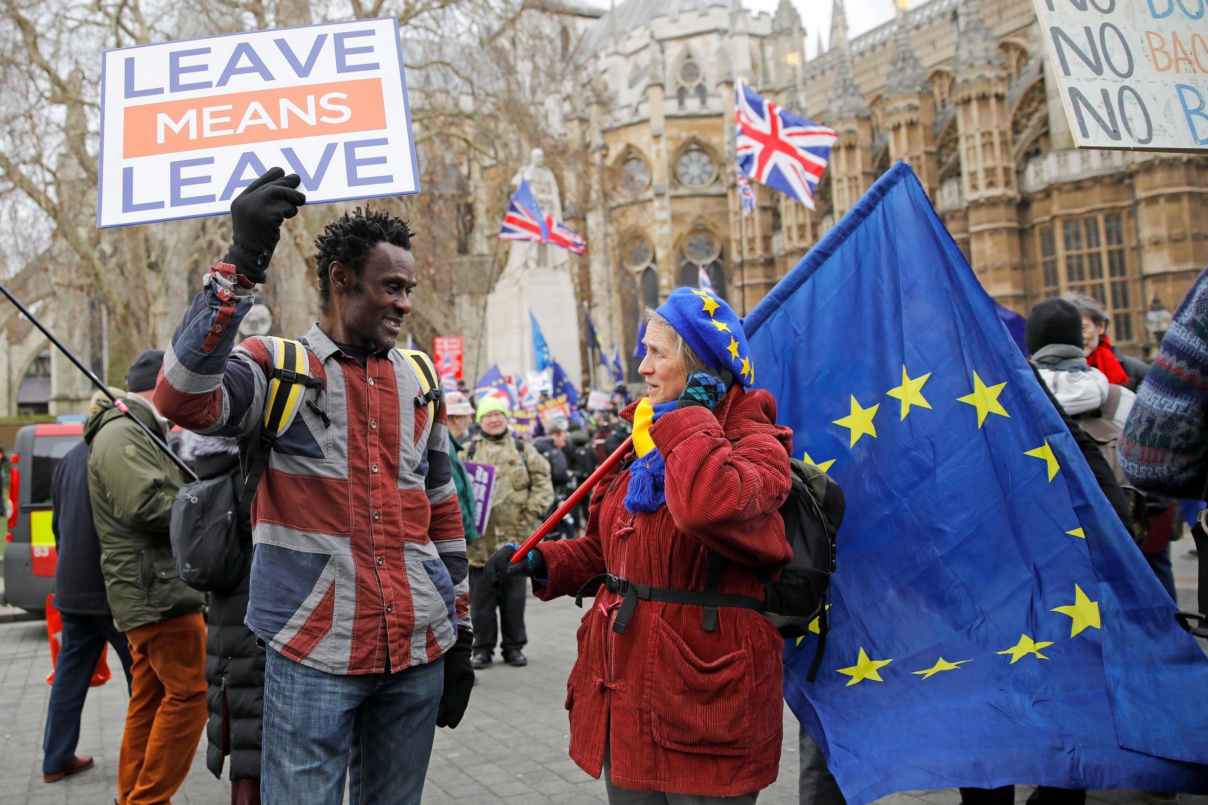 A pro-Brexit activist (left) talks with an anti-Brexit demonstrator as they protest near the Houses of Parliament