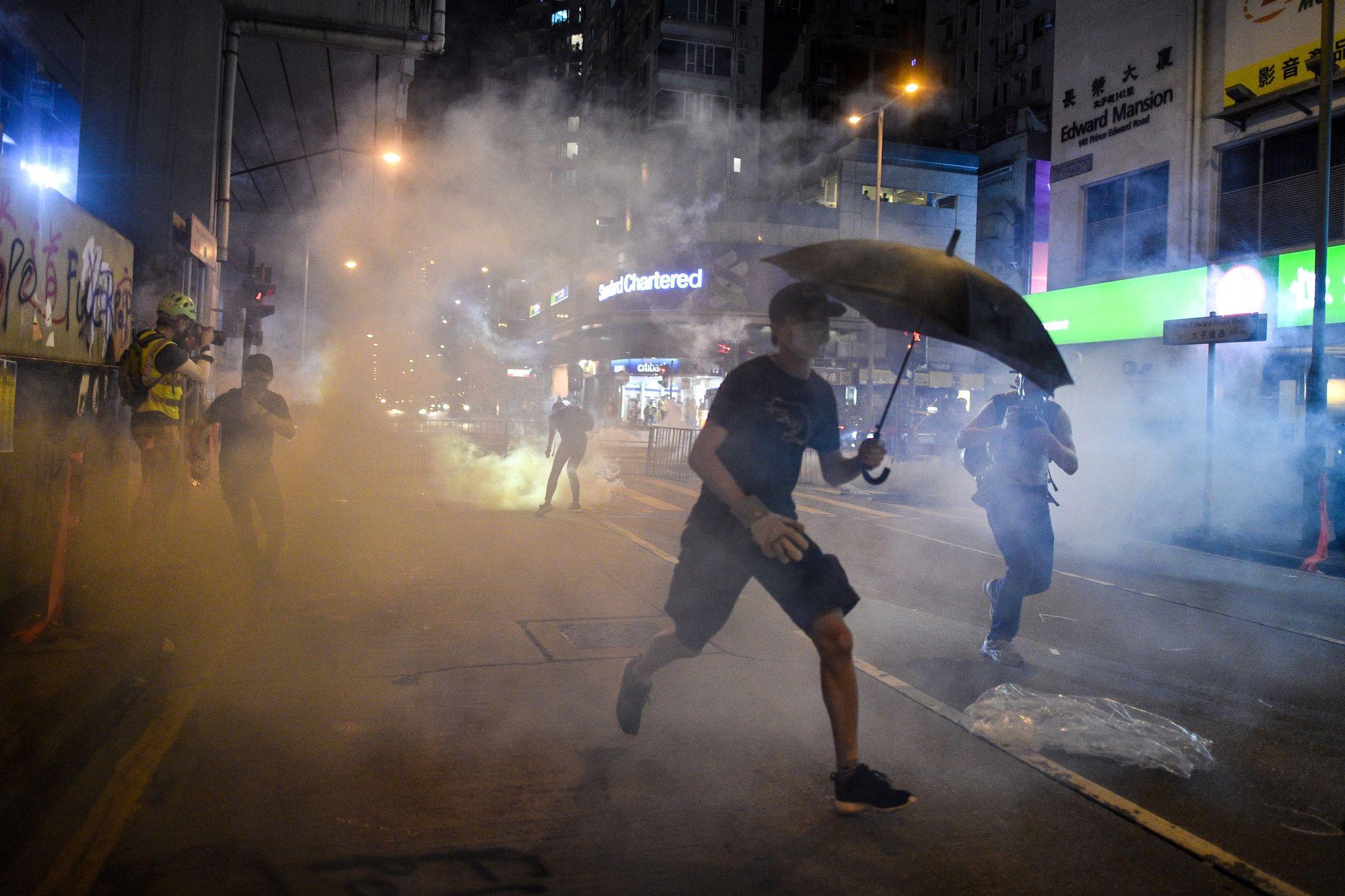 Protesters react after police fired tear gas in the Mong Kok district in Hong Kong on October 7, 2019