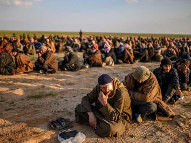 Suspected Isis fighters wait to be searched by the Kurdish-led SDF