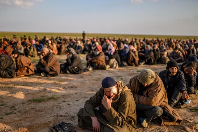 Suspected Isis fighters wait to be searched by the Kurdish-led SDF