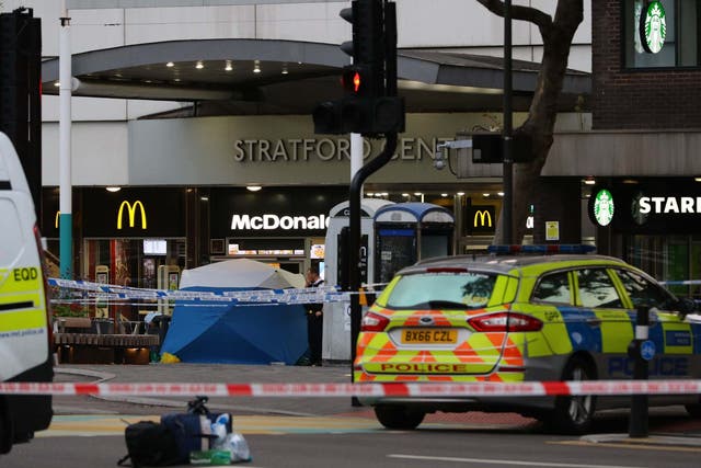 Police set up a forensic tent in front of an entrance to the Stratford Shopping Centre