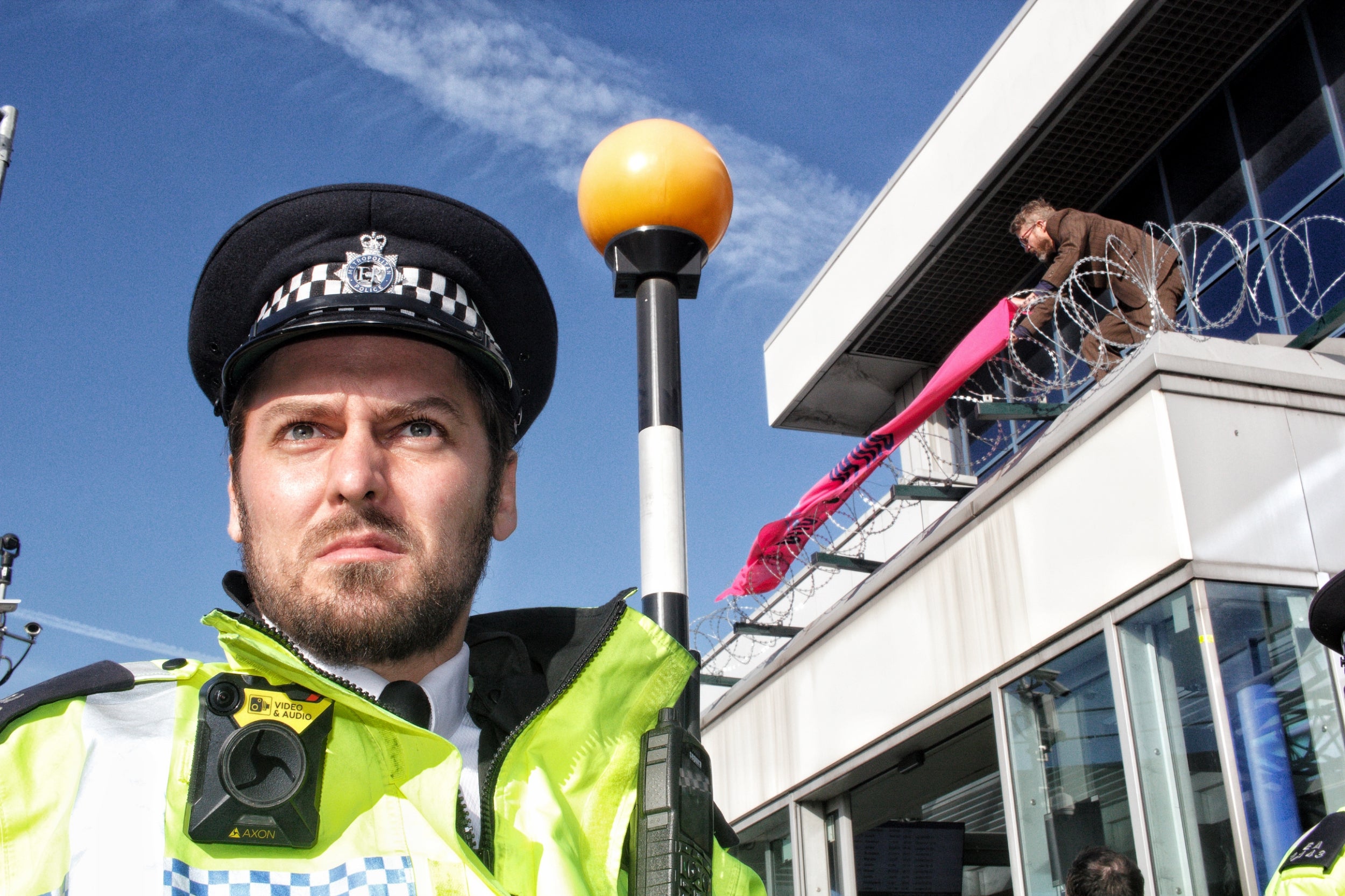 Protesters on the building at City airport as police form a line