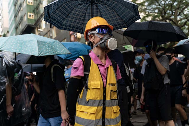 Pro-democracy volunteer stands in front of Tsim Sha Tsui Police Station as protesters march on a street on October 12, 2019 in Hong Kong
