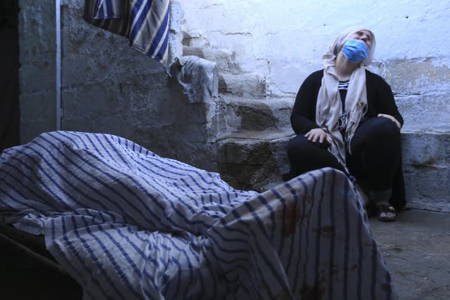 A woman mourns the death of a relative killed by Turkish army shelling in Qamishli