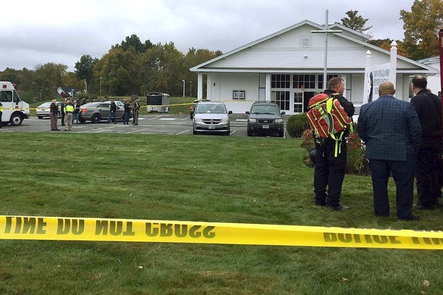 In this photo provided by WMUR-TV, police stand outside the New England Pentecostal Church after a shooting during a wedding on Saturday, 12 October 2019, in Pelham, New Hampshire.