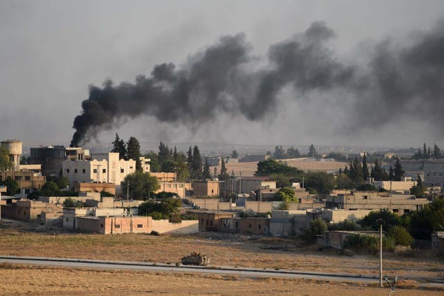 A Turkish army armored vehicle advances in Syrian city of Tel Abyad, as seen from the Turkish border town of Akcakale