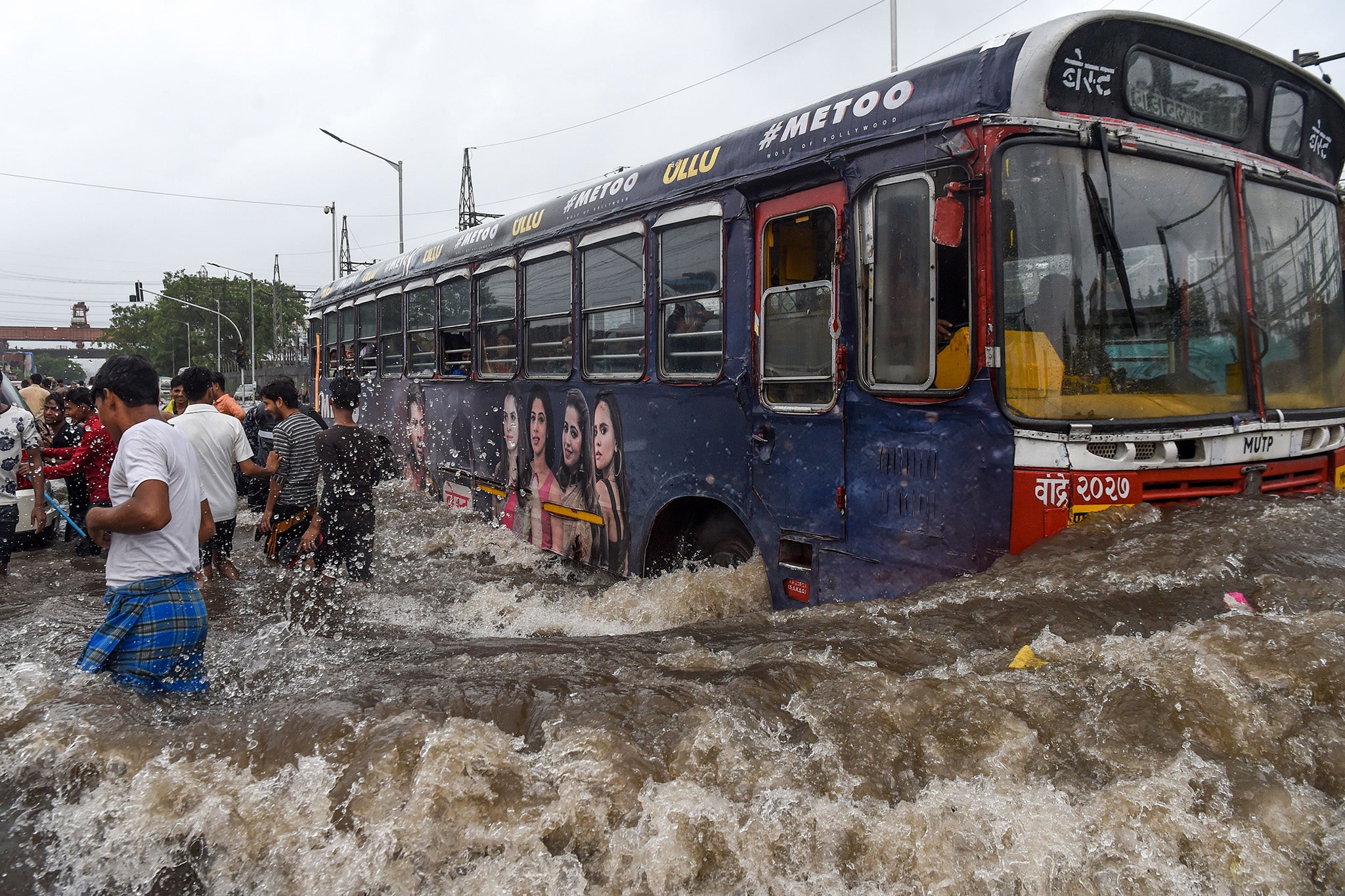 A public bus makes its way on a flooded road after heavy rains in Mumbai in August