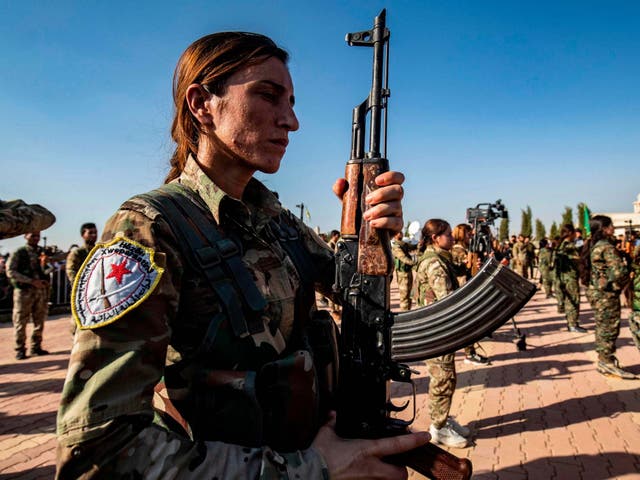 Kurdish fighters attend a funeral for political leader Hevrin Khalaf, who was reportedly executed by pro-Turkish militants in northeastern Syria