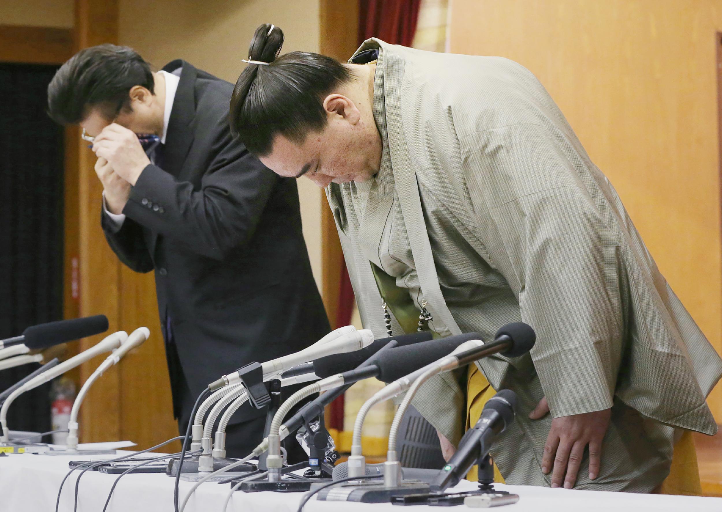 Harumafuj, a Mongolian-born yokozuna, bows to a press conference after announcing his retirement having admitted to assaulting a junior wrestler in 2017