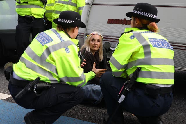 Police speak to an Extinction Rebellion protester outside MI5 Headquarters on Millbank in London