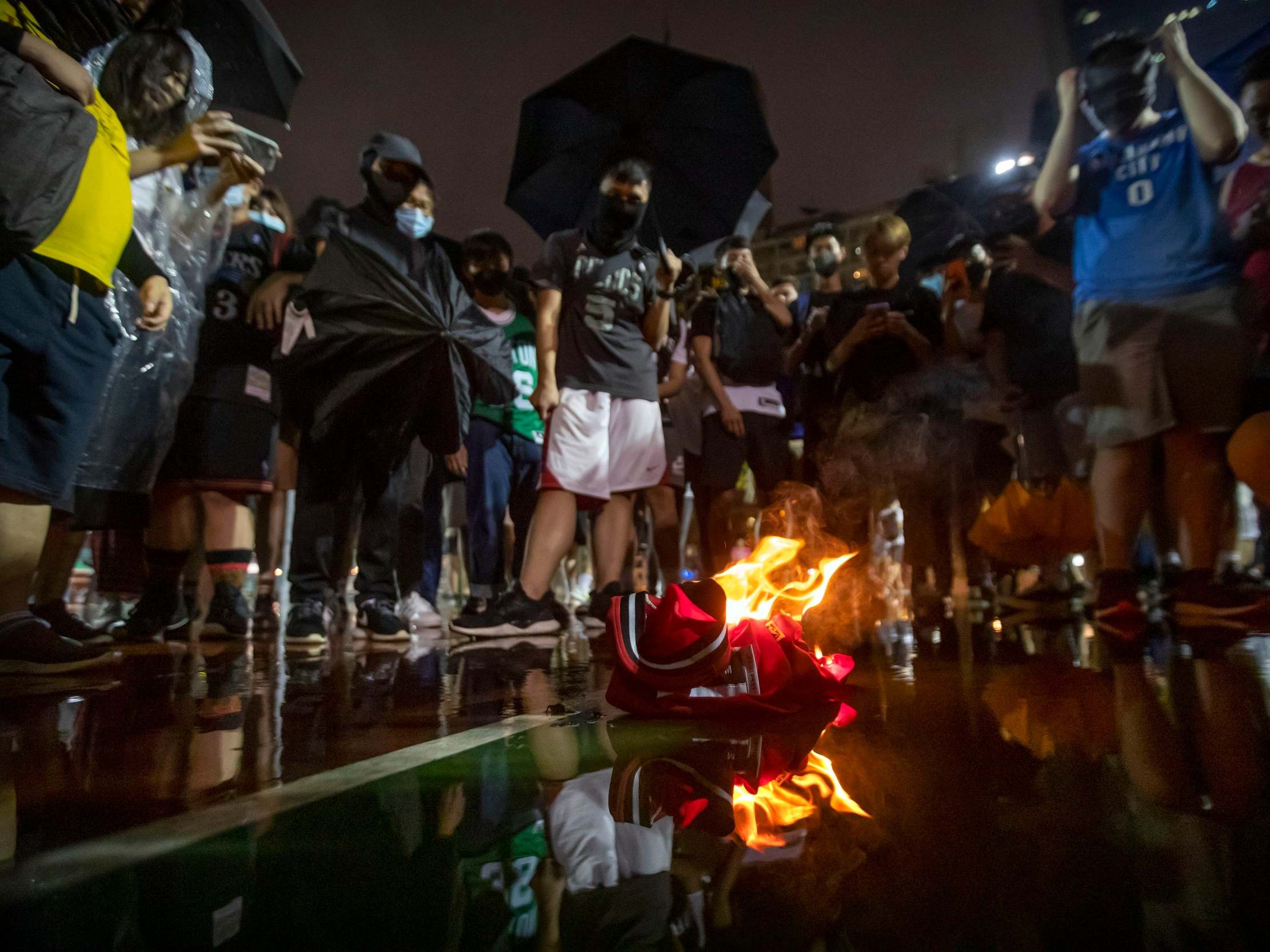 Demonstrators in Hong Kong burn a LeBron James basketball jersey in protest at his comments over free speech