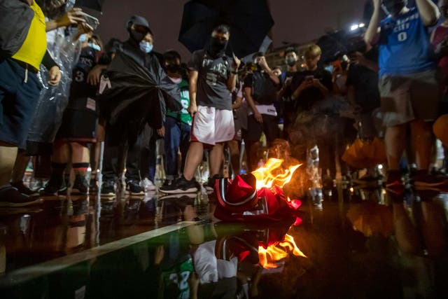 Demonstrators in Hong Kong burn a LeBron James basketball jersey in protest at his comments over free speech