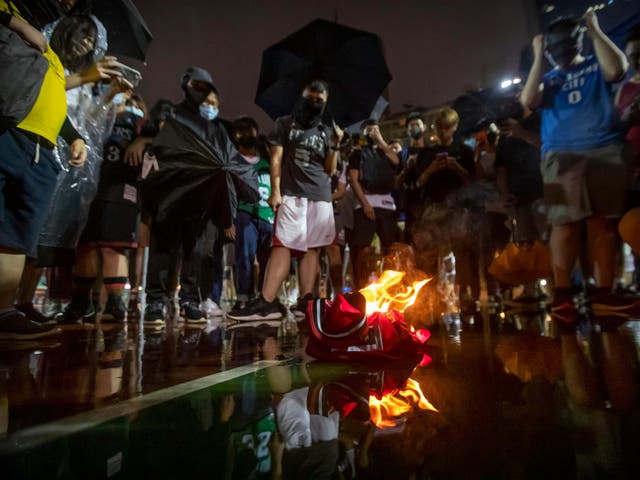 Demonstrators in Hong Kong burn a LeBron James basketball jersey in protest at his comments over free speech