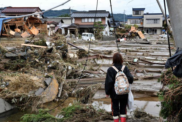 A woman looks at flood-damaged homes in Nagano after Typhoon Hagibis
